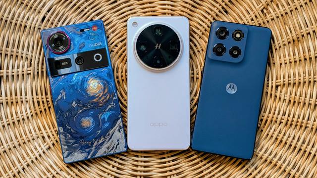 Three smartphones laying face down, side-by-side on a rattan table -- a blue Nubia Z70 Ultra Starry Night Edition (Left), pinkish white Oppo Find X8 Ultra (Center), and blue Moto G Stylus (2025) (Right)
