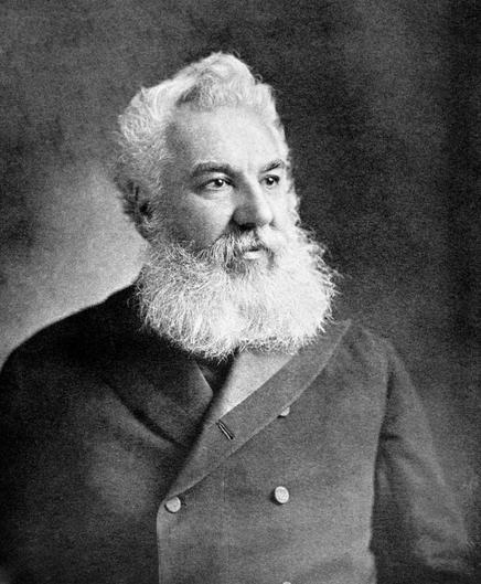 A black and white antique print from 1899 depicts Alexander Graham Bell (1847-1922). He is shown in a three-quarter portrait, looking slightly to his left. Bell has a full, neatly trimmed white beard and mustache. He's wearing a dark suit jacket with visible buttons. The image, © Georgios Kollidas | Dreamstime.com (stock photo ID 26655967), captures the inventor of the telephone in a formal pose.
