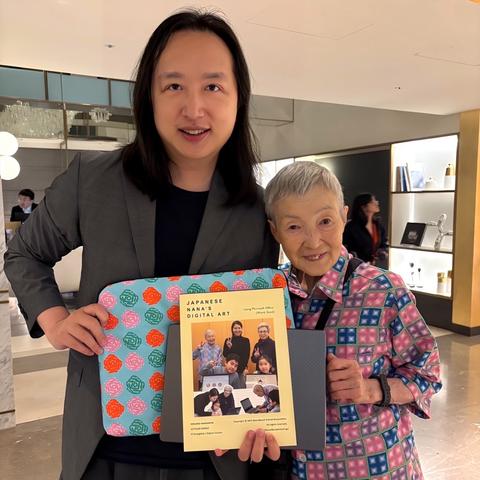 Audrey Tang (left), Taiwan’s cyber ambassador and 1st digital minister, and Ms. Masako Wakamiya (right), a nonagenarian app developer from Japan, holding exchanged gifts of a book on Japanese digital art, Excel art-designed sleeves for digital devices and a Taiwan-shaped bubble tea pin during a special joint birthday meetup in Taipei City.
