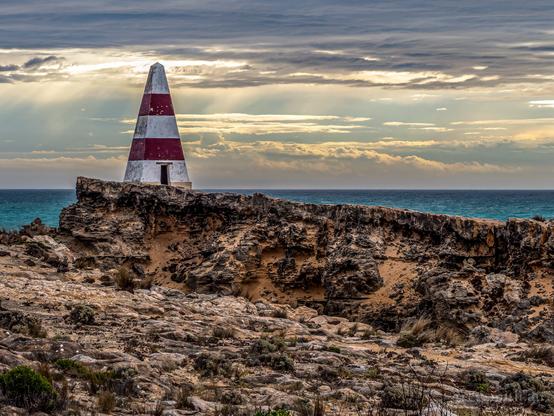 The Robe Obelisk and surrounding limestone cliffs, with a cloudy sky in the background.