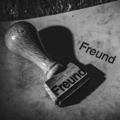 Ein Stempel mit dem Namen Freund und daneben ist ein Abdruck von diesem Namen zu sehen. Das Foto ist in Schwarzweiß.