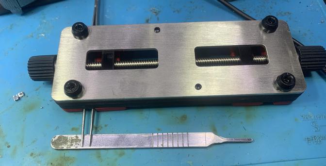 An upside down pcb vise, a pair of tweezers and a scalpel handle form an ersatz micromanipulator