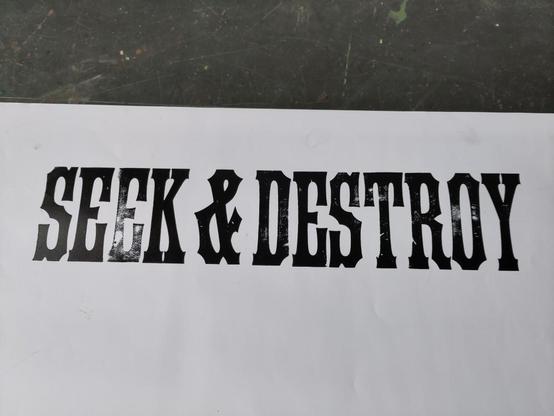 The words SEEK & DESTROY hand printed in black on white.