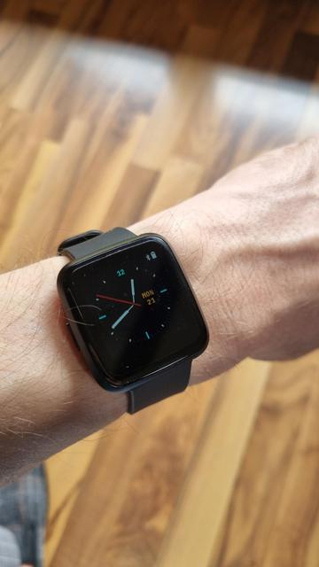 A PineTime running InfiniTime on it showing the hour on a wrist.