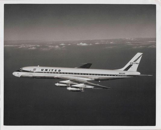 Black and white photo. The plane is flying right to left.
