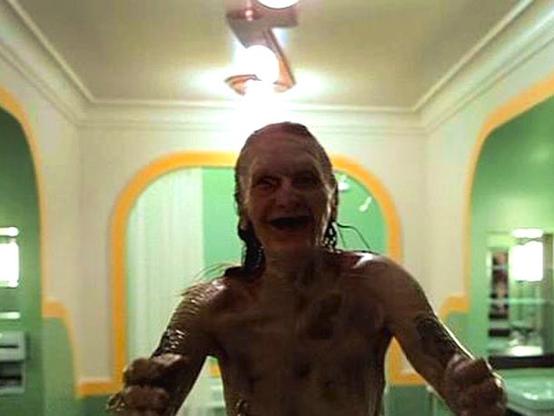 still from stanley kubrick's film, 'the shining', shows the art deco marvel that is the bathroom suite of room 237. an older woman in an advanced state of decay reaches out for the viewer.