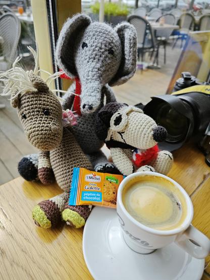 Espresso und ein kleiner Keks vor den drei Häkeltieren (ein Pferd, ein Elefant und ein Snoopy Hund).