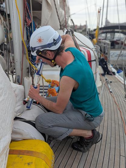 ein Crewmitglied repariert Ausrüstung an Deck