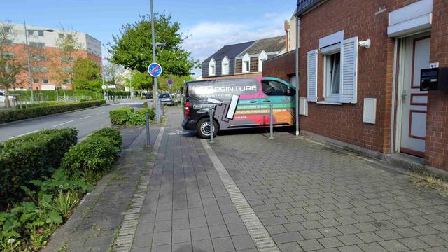 Une camionnette garée perpendiculairement comme une merde dont l'arrière déborde sur la moitier d'une piste cyclable.