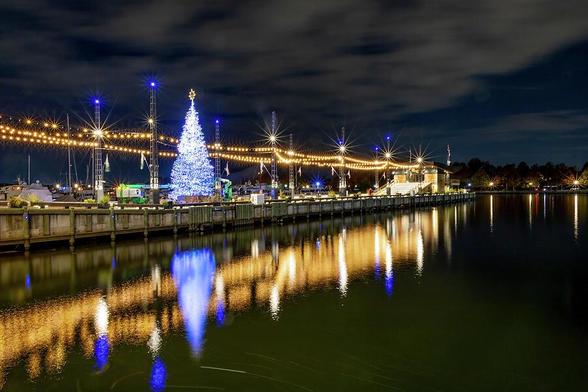 The Washington DC Wharf sparkles with festive lights, reflecting beautifully on the calm waters of the harbor.
