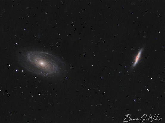 A small field of view barely containing both M 81 and M 82. M 81 is a spiral gallery with a bright core and wispy arms extending out into the dark background. M 81 is cigar shaped with a intricate splatter of red in the foreground.