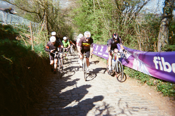 Cyclists riding up a cobbled hill