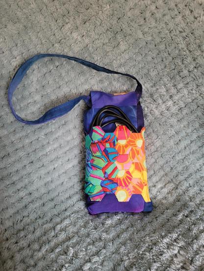 Photograph of the back of the same power bank case. A USB cable pokes out of the top of the pocket.