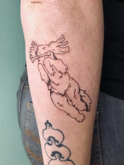 Tatouage handpoke dur le bras d’un cocker qui bondit