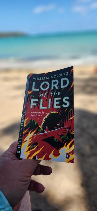 Reading The book Lord of the Flies on the beach.