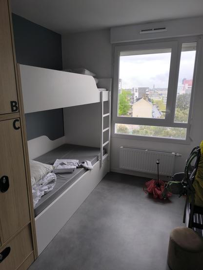 Blick ins Hostel Zimmer. Links ist das Stockbett, weiß und modern, rechts im Bild ein Fenster.