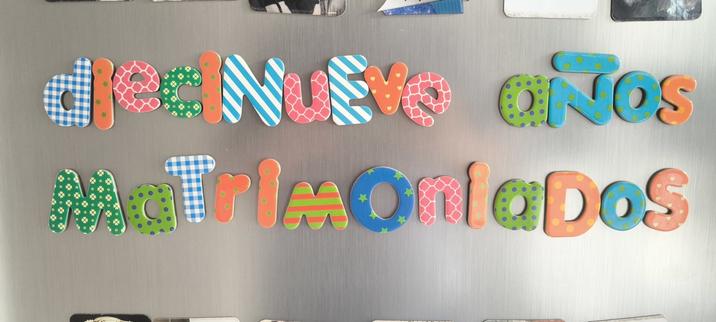 Letras que componen el texto: diecinueve años matrimoniados, con letras de colores con imán puestos en la puerta de la nevera