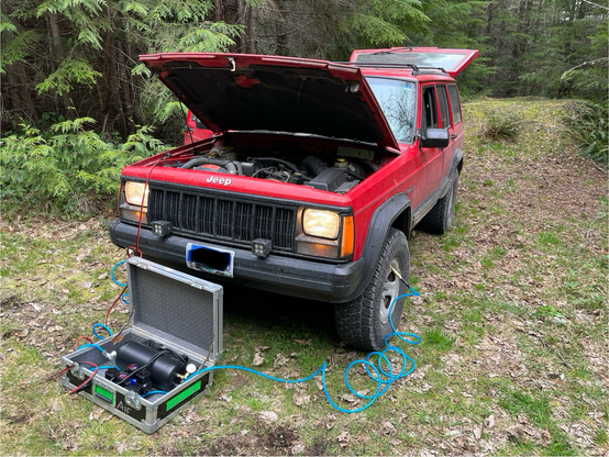 Airing up tires of a jeep after leaving the trail.