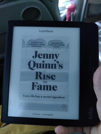 E-kirjan lukulaite, jonka näytöllä kirjan Jenny Quinn's Rise to Fame kansi.