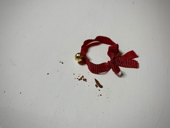 Schokoladenkrümel & ein rotes Band mit einem goldenen Glöckchen