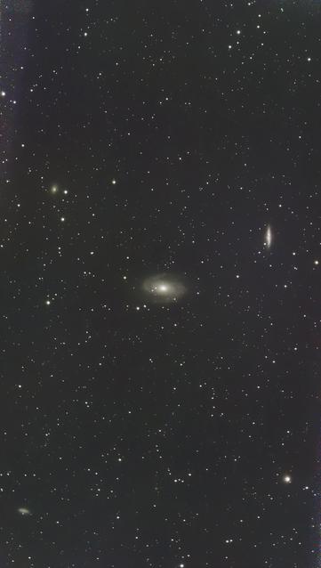 The night sky, dark with hundreds of pinpoint stars. There's a fuzzy disc in the middle and a fuzzy line above it to the left these are both distance galaxies.