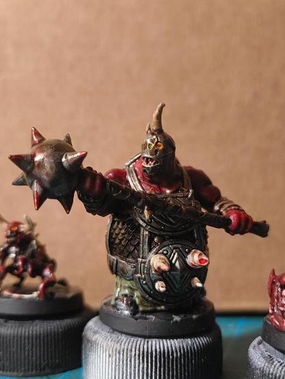A big demon with heavy armor and a giant morningstar. His face is hidden behind a metal face mask.
