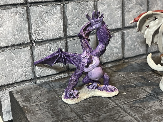 Reaper Miniatures Ape Demon painted in violet & lavender reminiscent of an early Windows adware mascot.