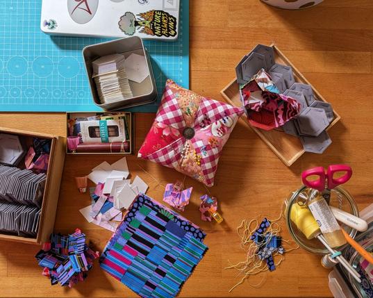 table surface littered with sewing parafernalia