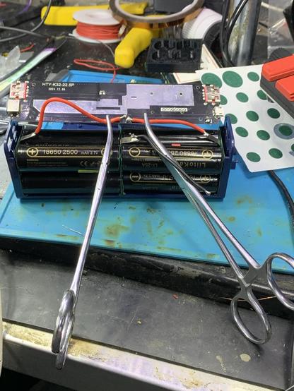 A pair of hemostats hold silicone coated wire in place for soldering to a battery management boards.  Try this with PVC wire and you might damage the insulation.