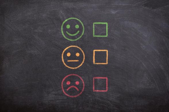 Dekoratives Bild: Smileys mit verschiedenen Gesichtsausdrücken (positiv, neutral, negativ) vor Checkboxen