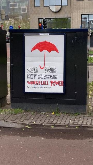 billbord wit op doner kastje met rode paraplu
zwart omlijne letters
waarvan 'workplace power' rood ingekleurd