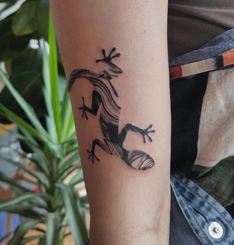 Gekko tattoo on an upper arm