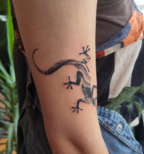 Gekko tattoo on an upper arm