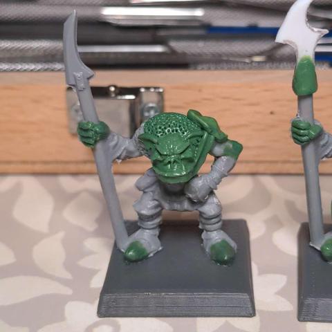 An in progress shot of a plastic model orc with various areas re-sculpted in epoxy putty