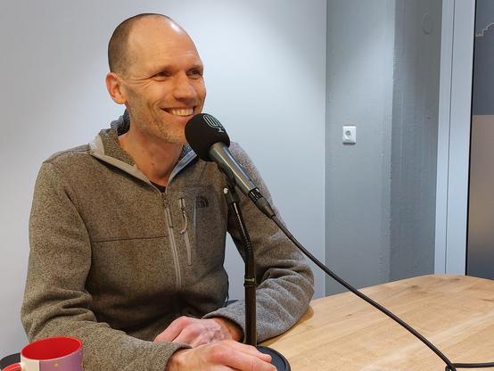 Michiel de Boer in front of a microphone during the recording of the podcast episode