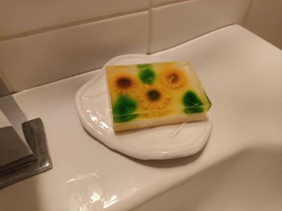 the same soap dish but with a soap on top with sunflowers and leafs,  but the colors are all a bit mixed and bled together
