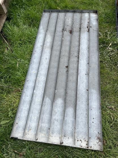 Aflang metalbakke med skinner på langs