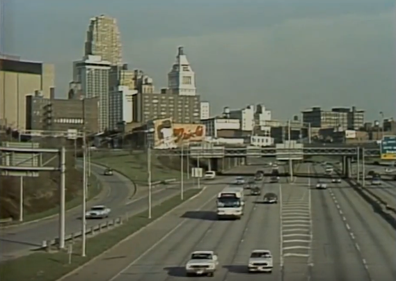 Screenshot from the Season 1 opening of "WKRP in Cincinnati" showing traffic passing the downtown business district