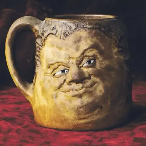 a clay pot designed to look like it has a face, with a smug expression
