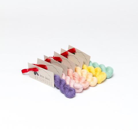 Picture shows six mini skeins of yarn positioned diagonally in a variety of colours.