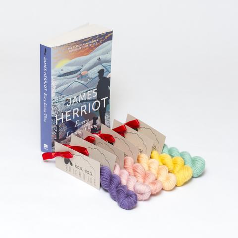 Picture shows six mini skeins of yarn positioned diagonally in a variety of colours. At the head of the yarn, stood on its end, is a copy of Jame Herriot's 'Every Living Thing'.