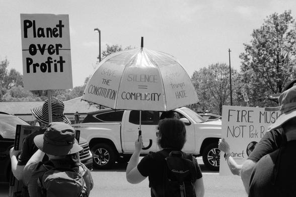 A clear umbrella with multiple slogans and signs pasted into each section