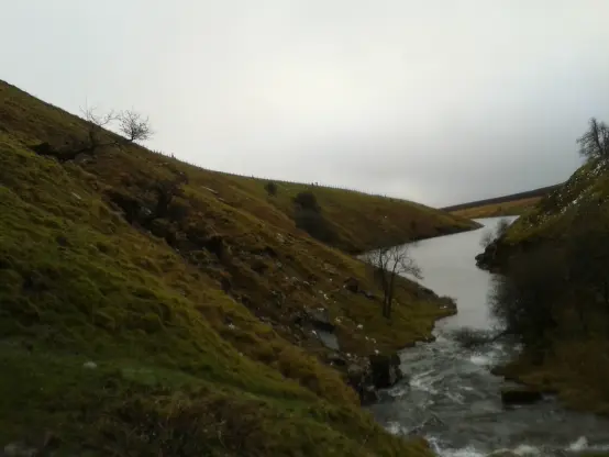 An image of water flowing between two hills