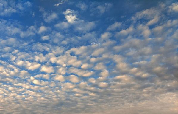 Picture of a blue sky with speckled white and gray clouds