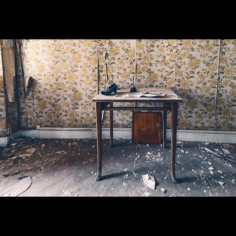 In an abandoned sanatorium, in a room , just a table with an old shoe , a bell and broken plates above.
Photo in color