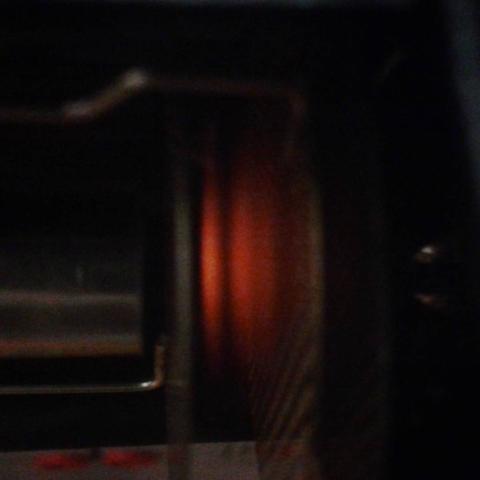 Two thin grids seen side on, between the grids there are two-three slices of gas that glows red