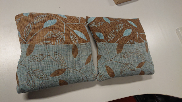 the two small finished cushions: they use a zipper-less design where two parts of the case overlap forming a 'tunnel' through which the filling can be inserted. They two halves of the cushion have contrasting color patterns (by using the same fabric but inside-out for part of it)