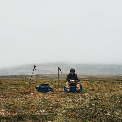 Photo of a friend reading a map during a hike in the Gaissene area, Finnmark, Norway.
