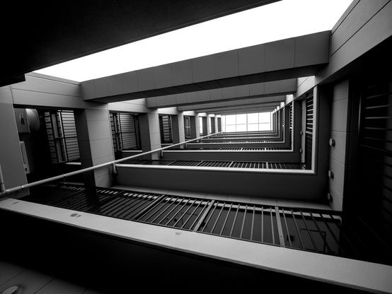 High contrast shot of architecture, looking up through a space in hotel floors.