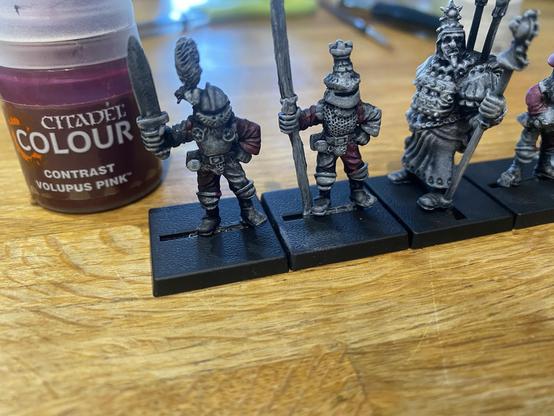 A pot of Volupus Pink beside some miniatures that it’s been applied to. The miniatures have a great Oldhammer vibe.